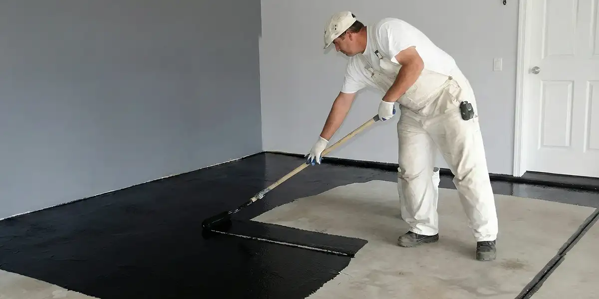basement waterproofing professional applying waterproof coating to protect a basement floor in Austin, TX